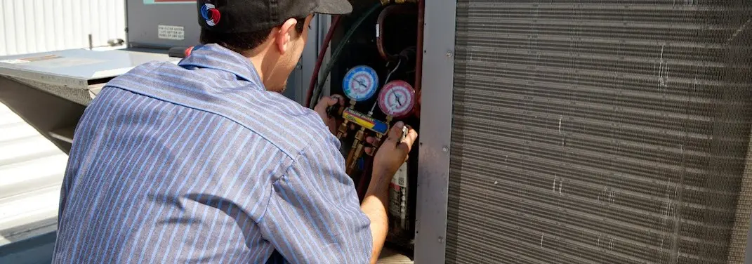 HVAC technician servicing a condenser unit in Arlington